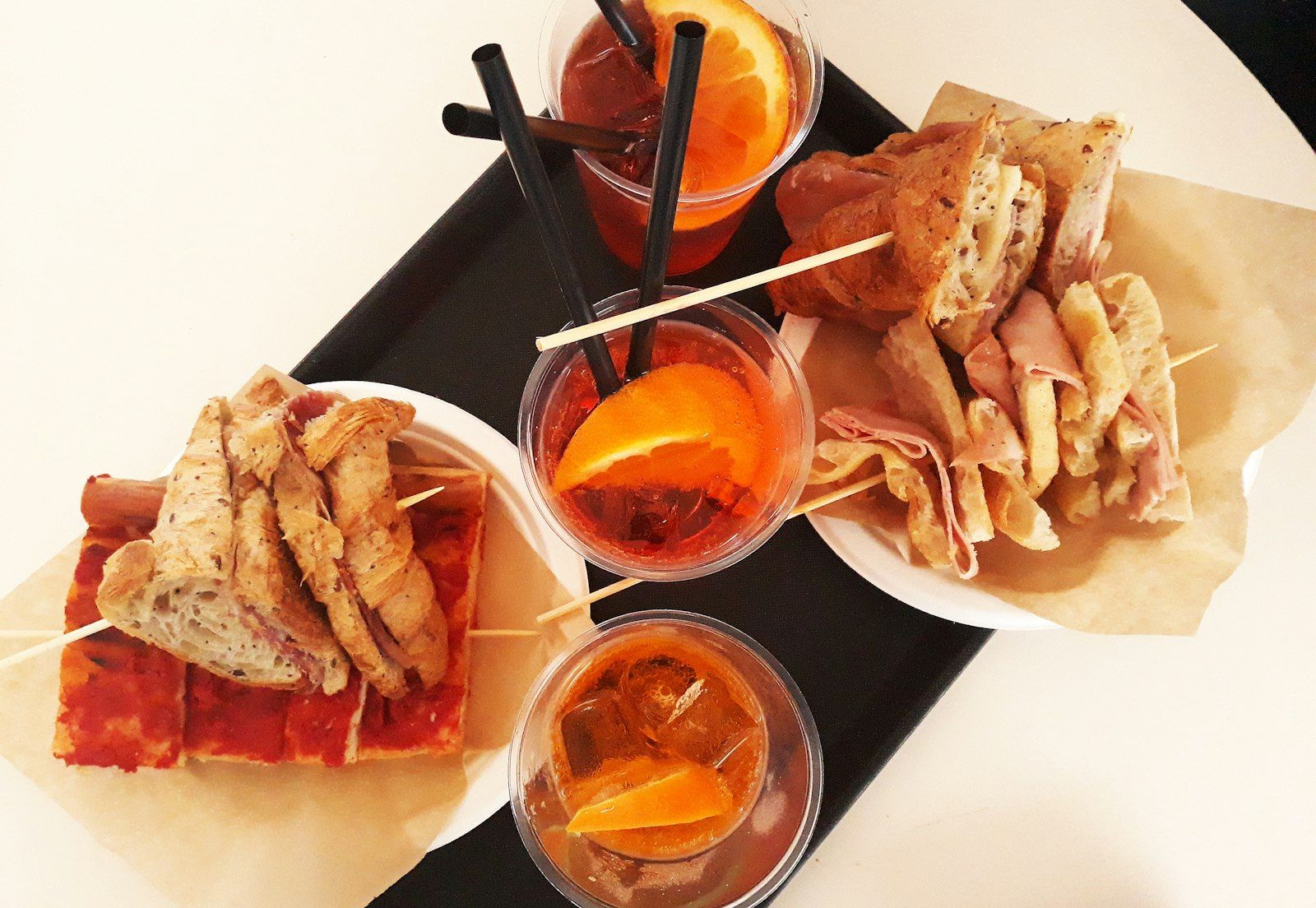 Spritz con stuzzichini su un vassoio nero